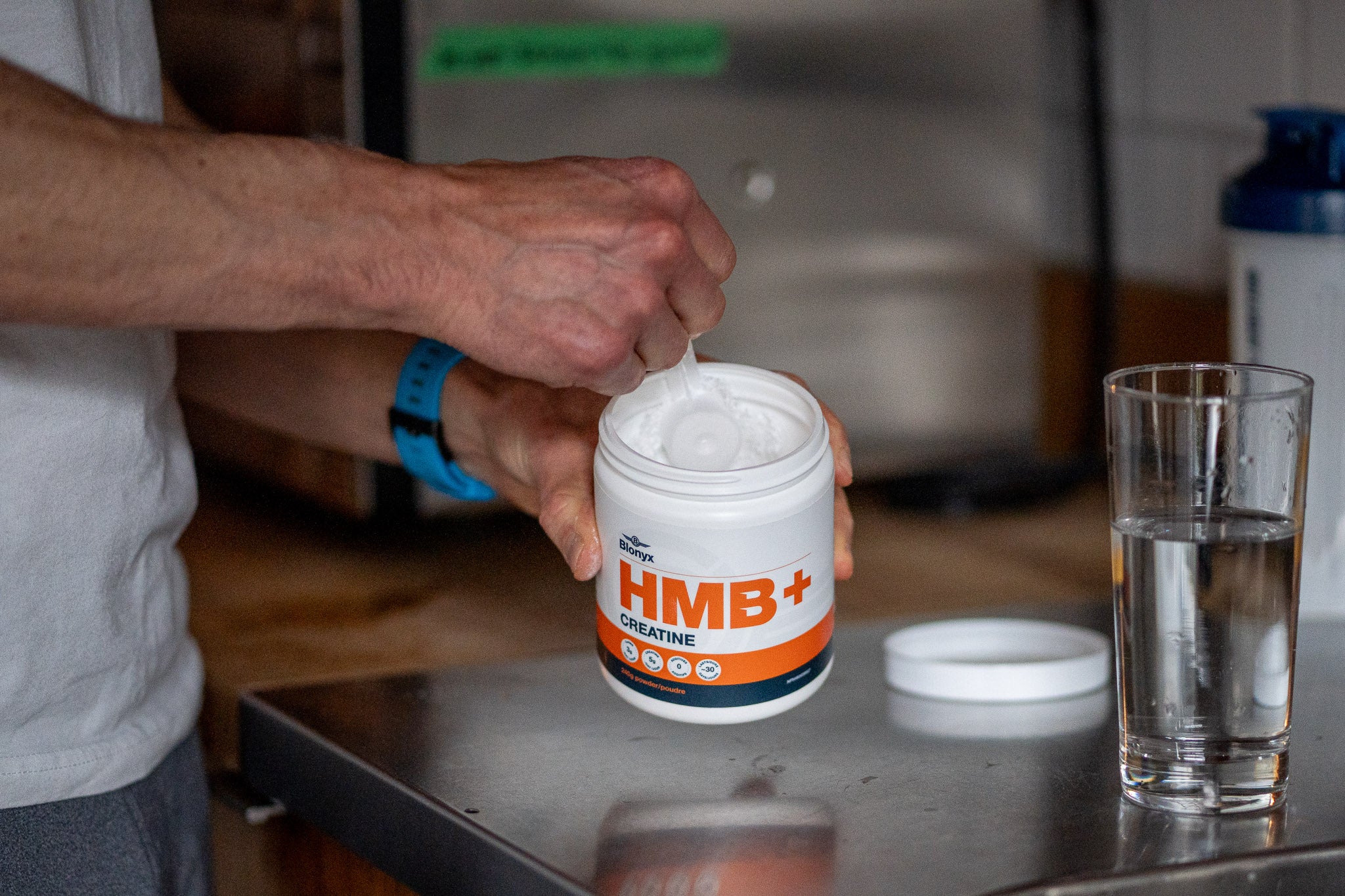 Athlete scooping Blonyx HMB+ Creatine out of the tub