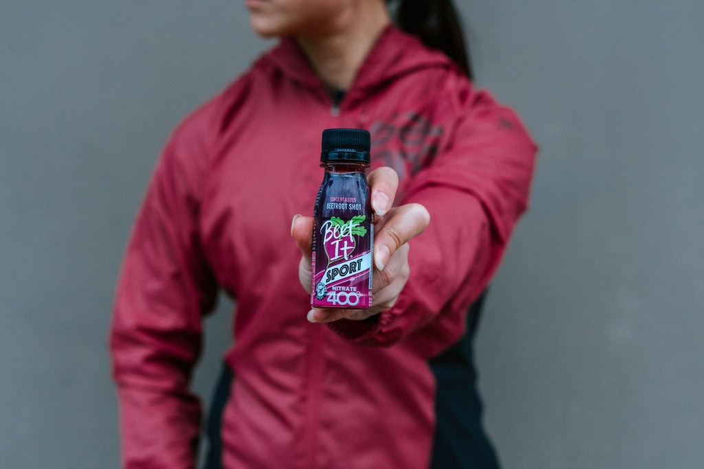 Runner holding a bottle of Beet It Sport Nitrate 400