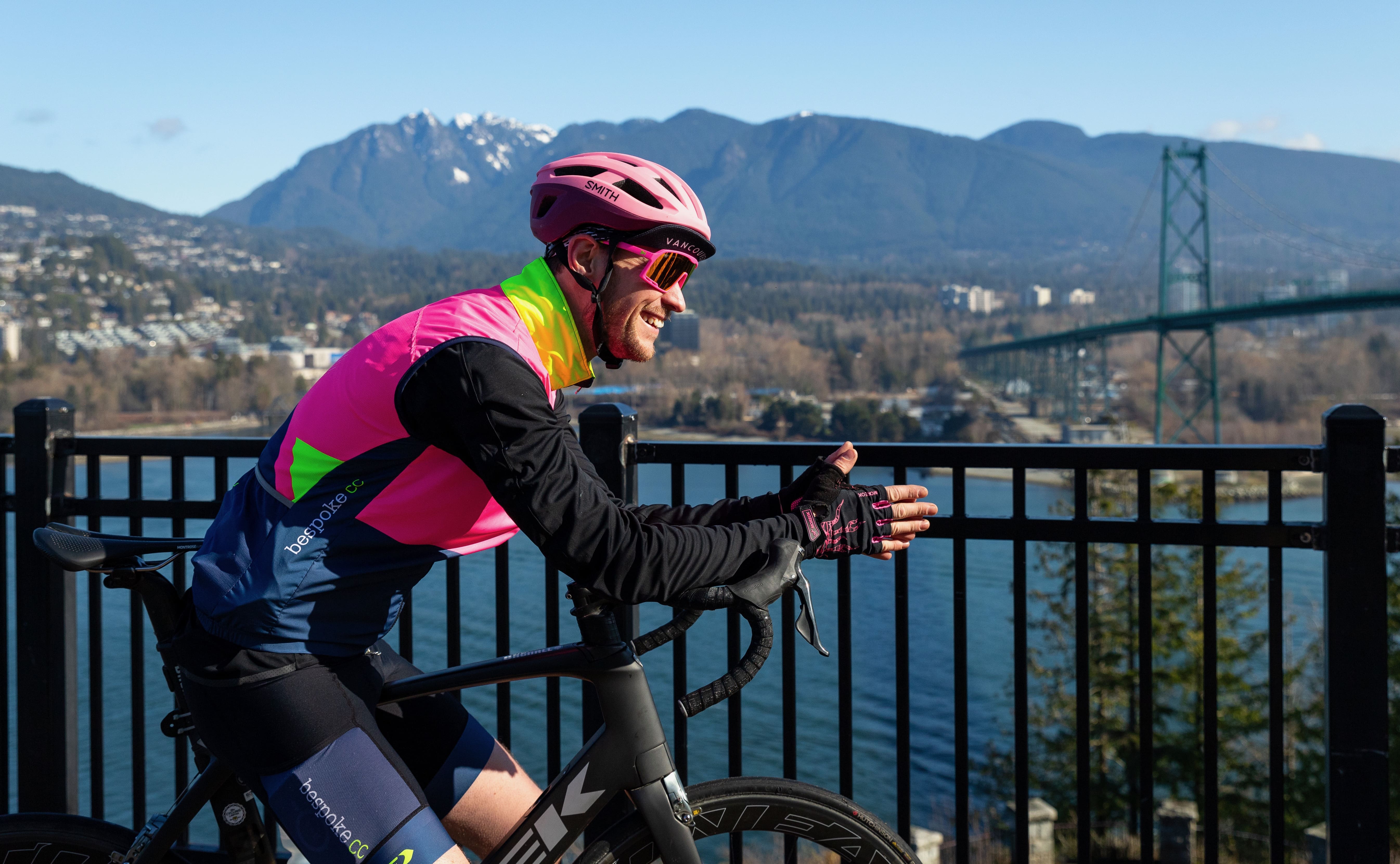 Cyclist looking out over North Vancouver and the Lions Gate Bridge
