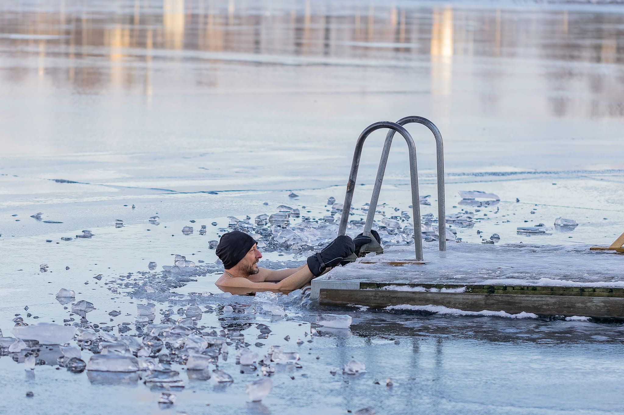 Man Emerging from Cold Water of Frozen Lake