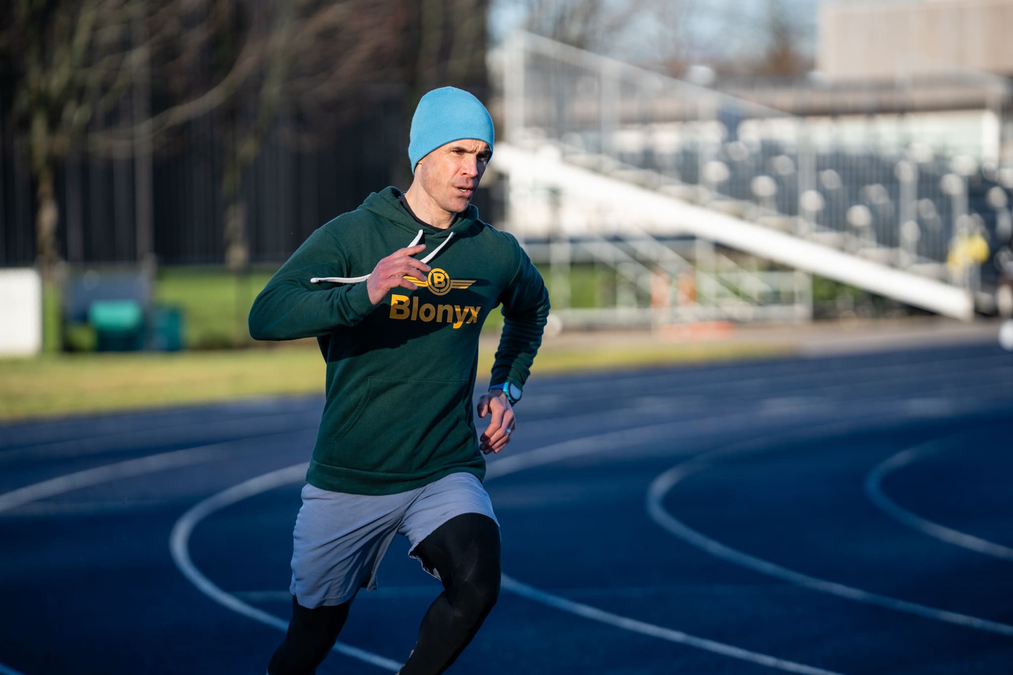 Male runner training on an outdoor track during a 5K running workout.