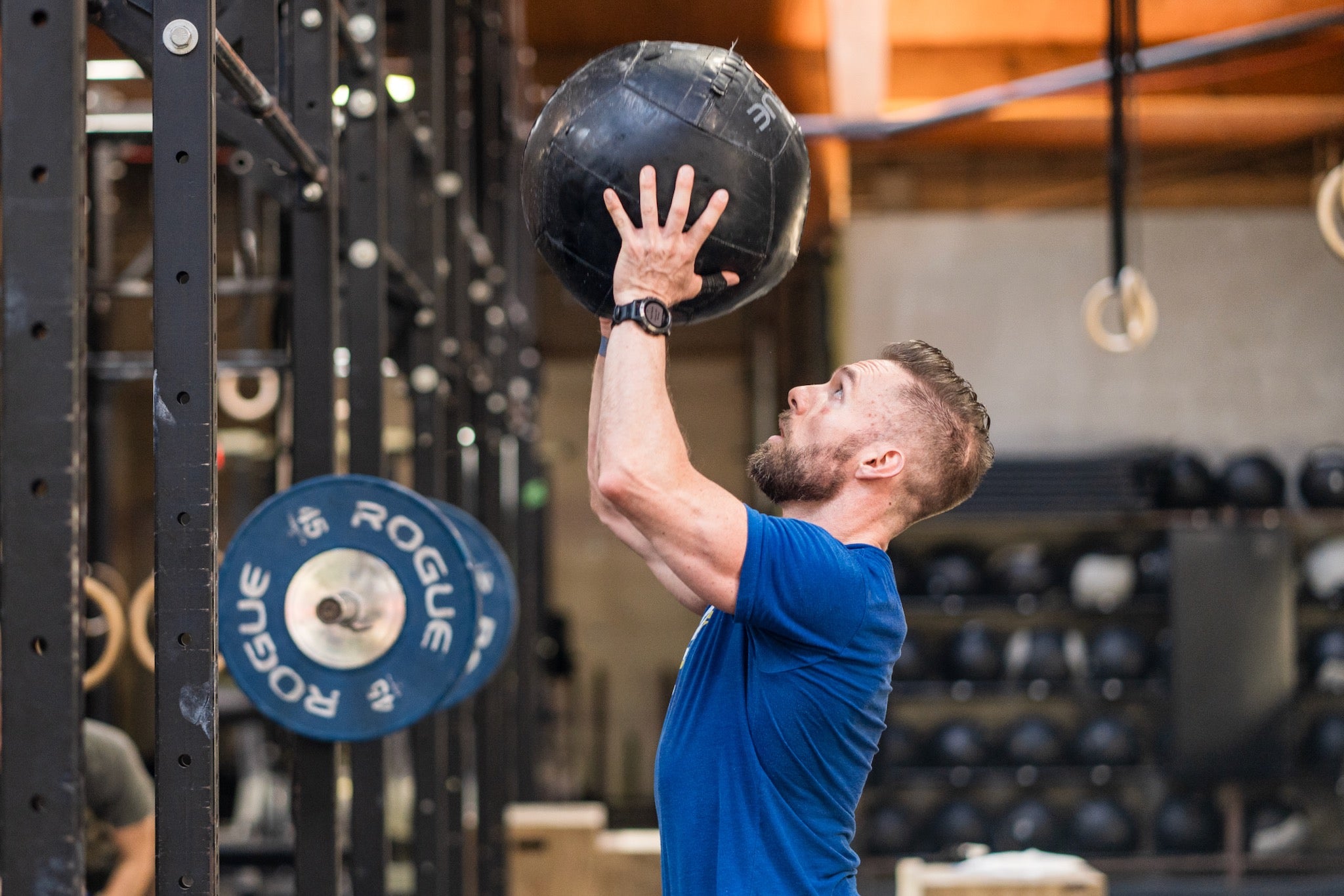 CrossFit athlete lifting a medicine ball above his head