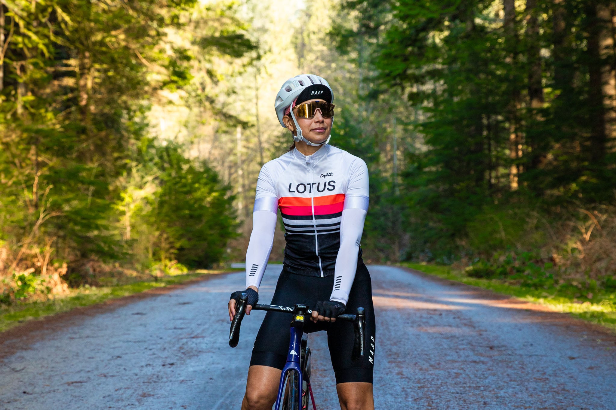 Female cyclist on a road through the forest