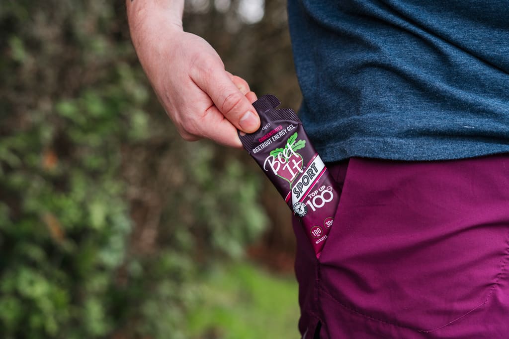 Athlete holding a Beet It Sport Top Up 100 nitrate energy gel