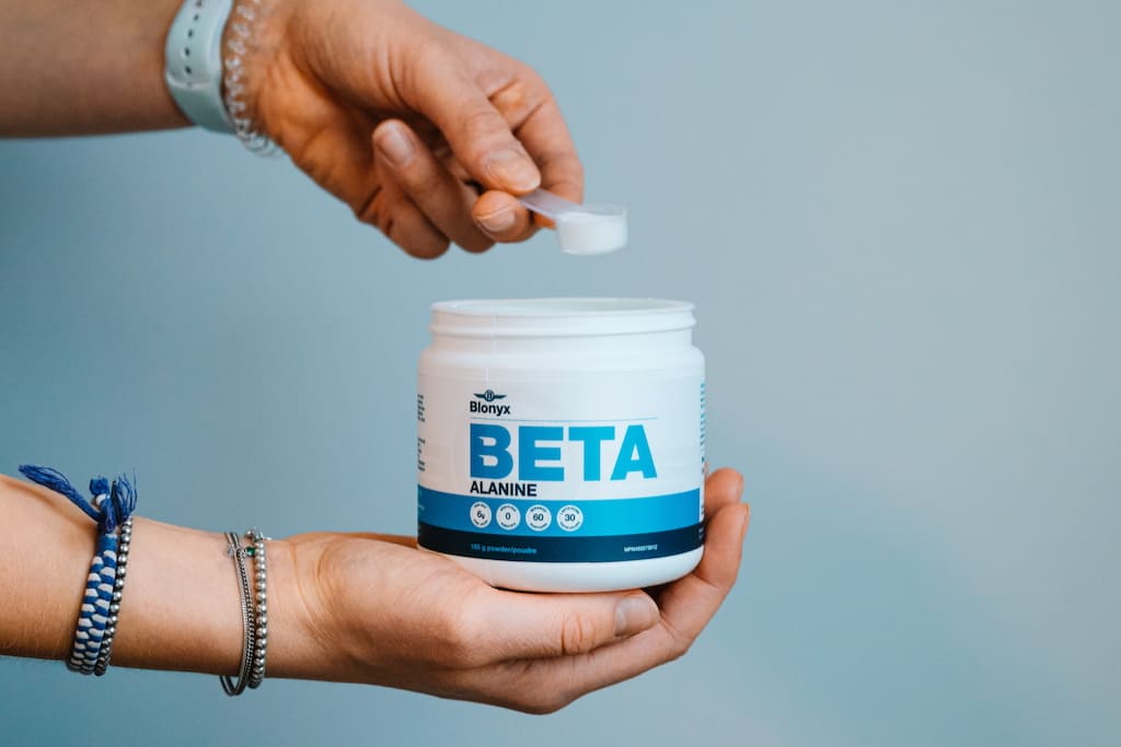 A person holding a tub of Blonyx Beta Alanine.