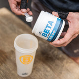 Strength athlete scooping Blonyx Beta Alanine into a shaker bottle