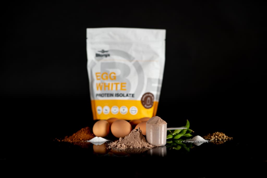 Blonyx Egg White Protein Isolate and its ingredients on a dark table.